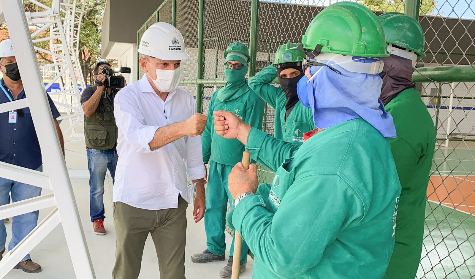 prefeito cumprimeira um operário no canteiro de obras da escola